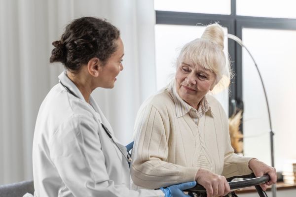 Carer helping an elderly woman 